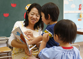 絵本を読む園児と先生